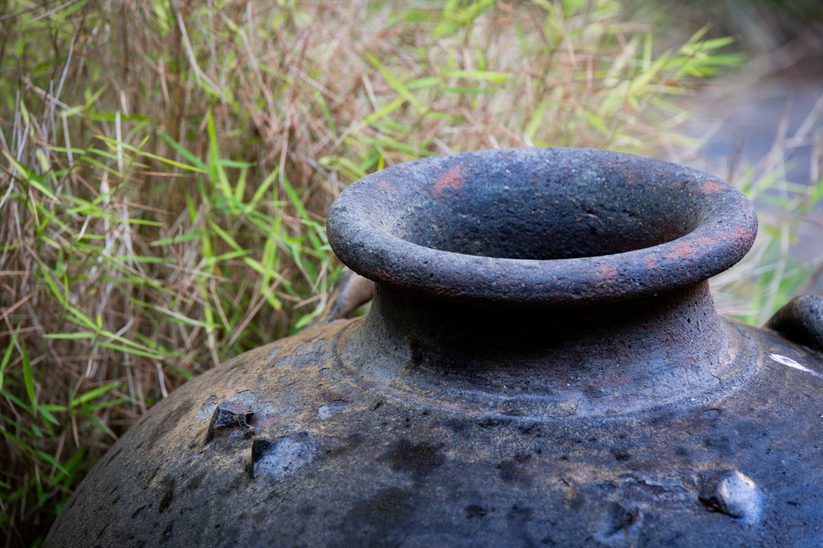 Weathered clay vessel — illustrative photo; ceramic offerings were common in pre-Columbian burials