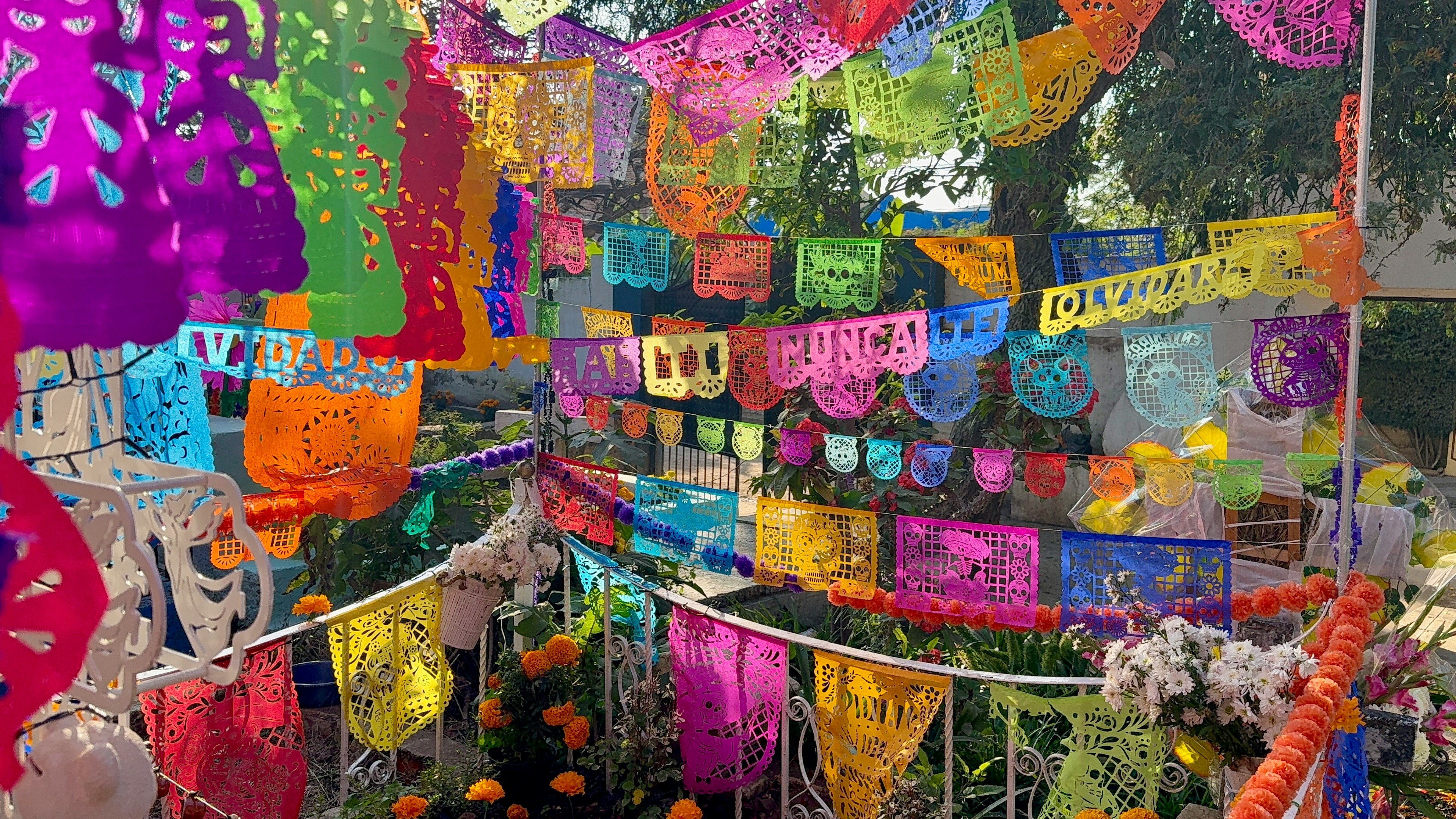Colorful papel picado banners and marigold flowers at a cemetery in Ajijic, Mexico